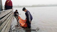 petugas pmi beserta warga saat mengevakuasi jenazah seorang ibu