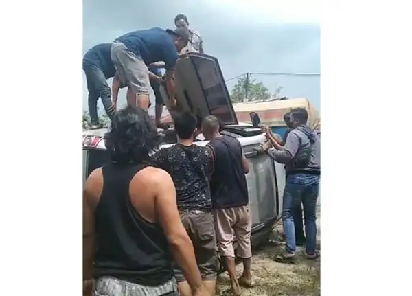 puluhan warga mengevakuasi penumpang mobil yang terlibat tabrakan