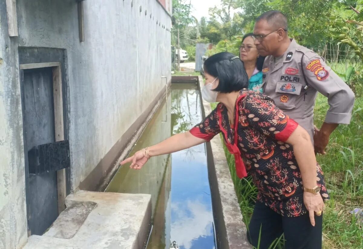 Petugas kepolisian bersama korban saat berada di lokasi kejadian