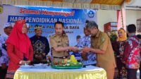 Wali Kota Palangka Raya Fairid Naparin saat memberikan potongan nasi tumpeng kepada Kadis Pendidikan Kota Jayani, saat memperingati Hardiknas 2023 di SMPN-1 Palangka Raya, Selasa (2/5).(dodi/radarsampit)