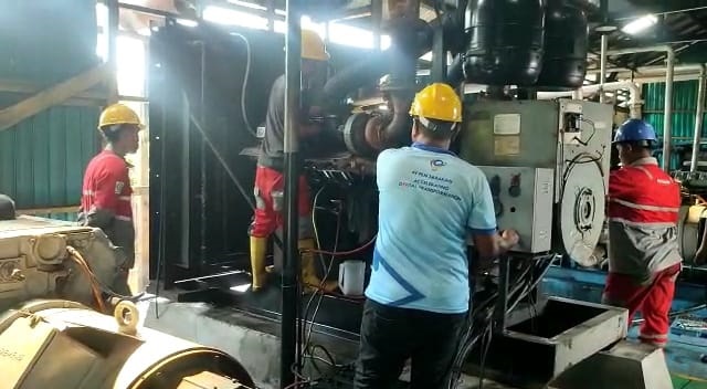 Petugas mekanik PLN ketika memperbaiki salah satu mesin pembangkit di Desa Pegatan