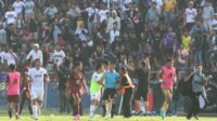 petugas mengamankan wasit dari lemparan suporter saat pertandingan persik kediri melawan psm makassar pada kompetisi liga 1 di stadion brawijaya, kota kediri, jawa timur, senin (18/12/2023).