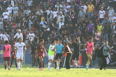 petugas mengamankan wasit dari lemparan suporter saat pertandingan persik kediri melawan psm makassar pada kompetisi liga 1 di stadion brawijaya, kota kediri, jawa timur, senin (18/12/2023).