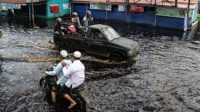 warga memanfaatkan jasa transportasi mobil bak terbuka untuk melintasi banjir yang merendam jalan trans kalimantan di desa tumbang nusa, pulang pisau, kalimantan tengah,