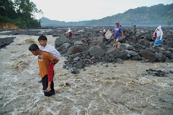 siswa sekolah dasar (sd) melintasi daerah aliran sungai (das) kali regoyo untuk berangkat sekolah di desa jugosari, kecamatan candipuro, lumajang, jawa timur
