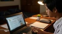 Anak belajar menggunakan laptop di kamar pada malam hari.